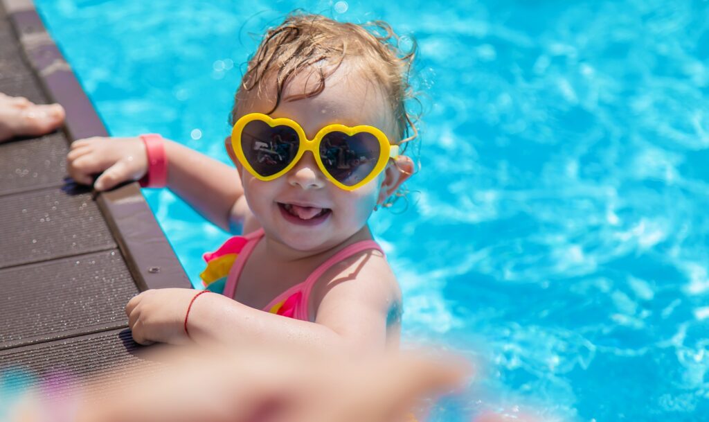 Baby swims in the pool. Selective focus.
