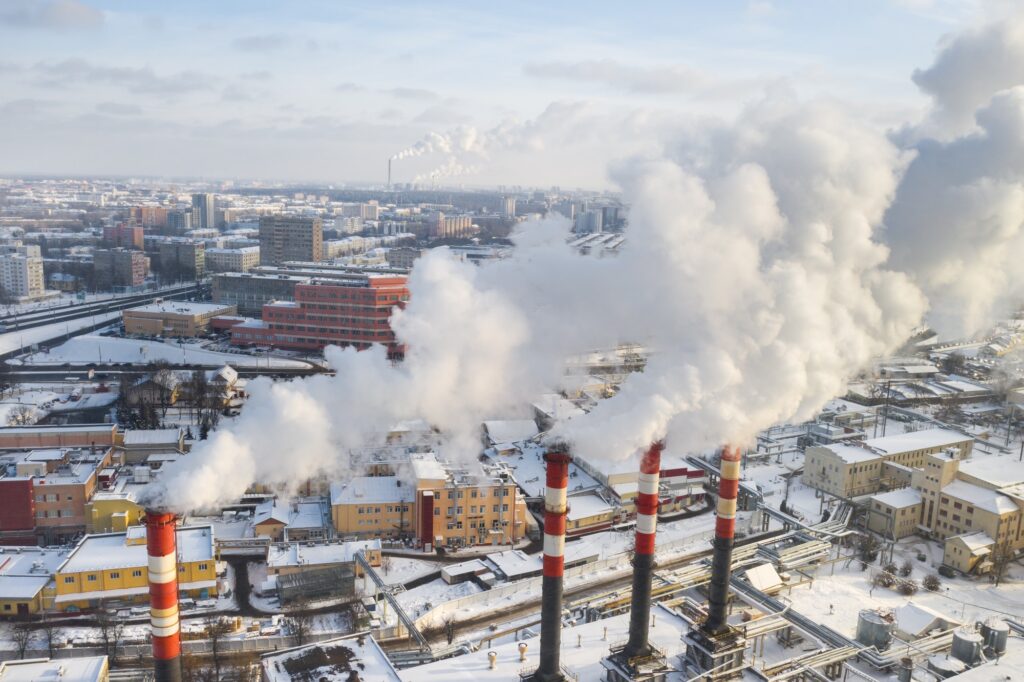 In the winter city, the factory's chimneys are smoking. The concept of air pollution