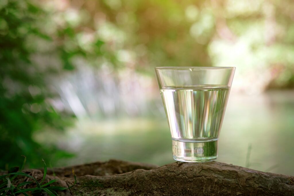 A glass of clean water, on the nature. Concept of a healthy lifestyle
