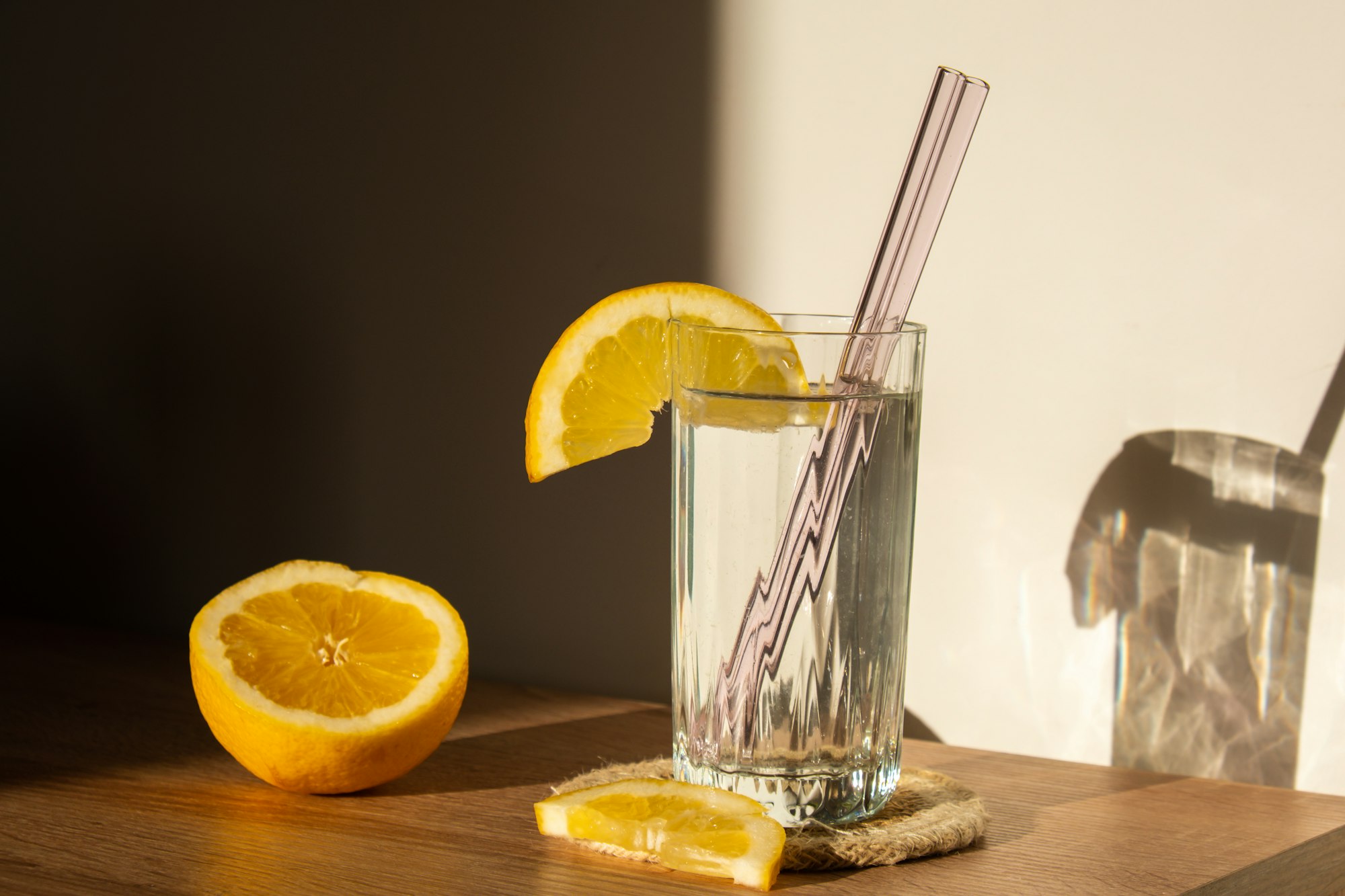 Glass of water with fresh lemon juice with Reusable glass Straws Detox cold tonic water with sunny